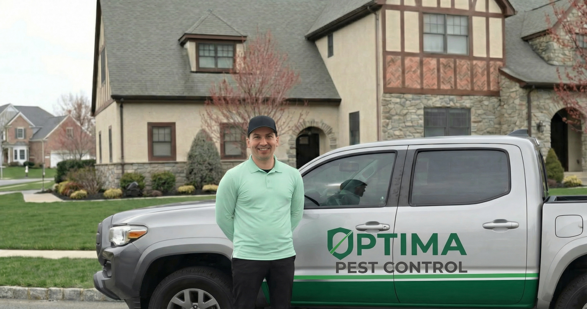 Optima Pest Control owner standing next to the branded service truck